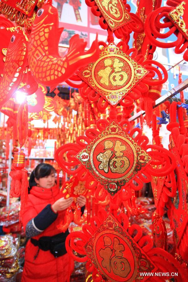 A customer selects ornaments to greet the upcoming Spring Festival, which falls on Feb. 10 this year, in Jimo City, east China's Shandong Province, Jan. 8, 2013. (Xinhua/Liang Xiaopeng) 