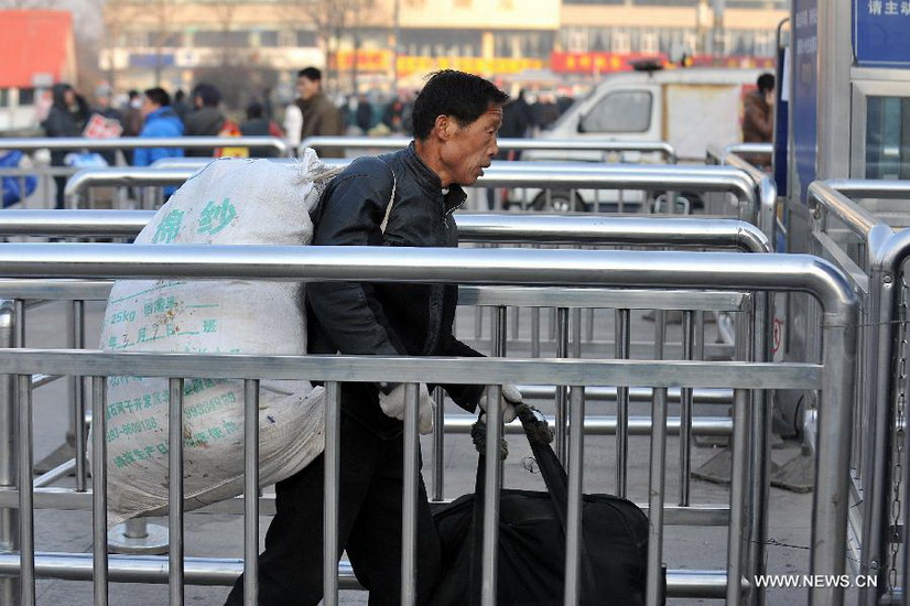 An immigrant worker walks into the Taiyuan Railway Station in Taiyuan, capital of north China's Shanxi Province, Jan. 8, 2013. As the Spring Festival draws near, immigrant workers have begun to go home for a family reunion, leading a travel peak at the railway station. The Spring Festival, the most important occasion for a family reunion for the Chinese people, falls on the first day of the first month of the traditional Chinese lunar calendar, or Feb. 10 this year. (Xinhua/Yan Yan) 