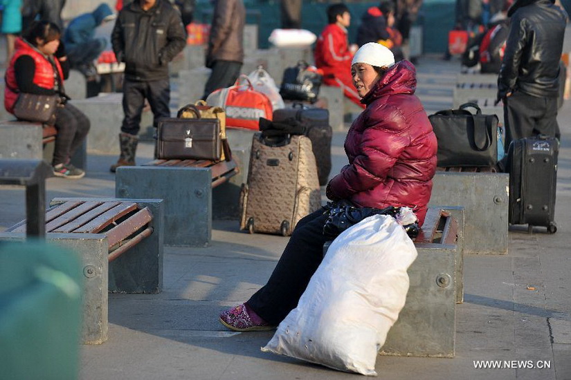 An immigrant worker wait for a train at the Taiyuan Railway Station in Taiyuan, capital of north China's Shanxi Province, Jan. 8, 2013. As the Spring Festival draws near, immigrant workers have begun to go home for a family reunion, leading a travel peak at the railway station. The Spring Festival, the most important occasion for a family reunion for the Chinese people, falls on the first day of the first month of the traditional Chinese lunar calendar, or Feb. 10 this year. (Xinhua/Yan Yan) 