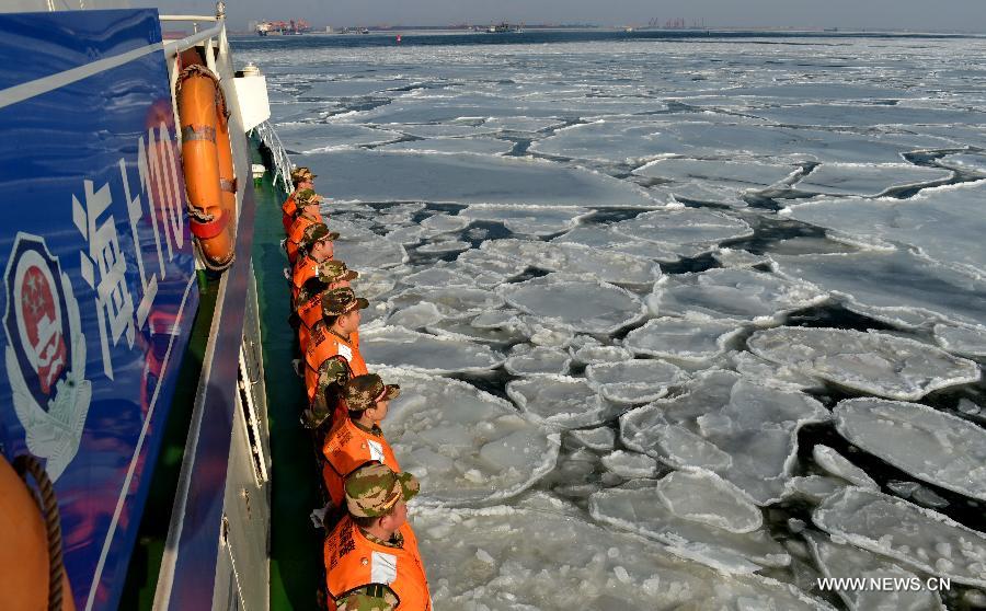 Local coastal police officers are on duty on the sea covered by drift ice, in Qinhuangdao, north China's Hebei Province, Jan. 8, 2013. A cold snap has created a layer of thick sea ice in the offshore areas of the Bohai Bay in Hebei Province. (Xinhua/Yang Shiyao)