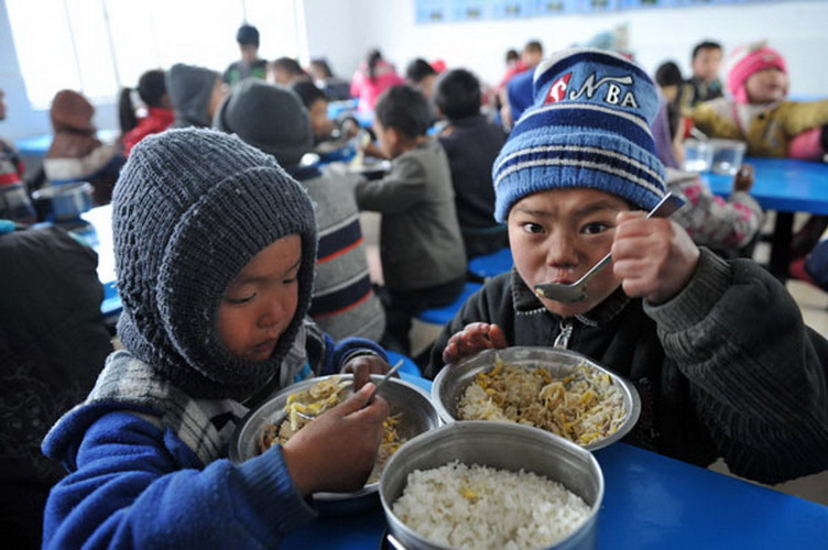 Students enjoy free lunch at Longdong Primary School in Longlin county, Guangxi Zhuang autonomous region, Jan 8, 2013. (Photo/Xinhua)