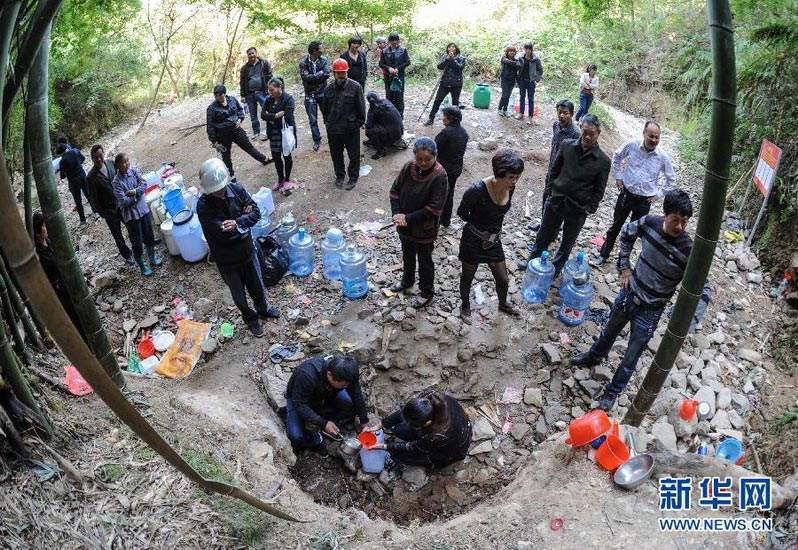 Citizens queue to take mountain spring from a puddle in Wenling, Zhejiang on Oct. 19, 2012. During the National Day holiday, people swarmed to the mountain to get the “sacred water” as they believed it can cure diseases. But according to the result of water sample test, the “sacred water” does not meet the national drinking water standard. (Xinhua/Han Chuanhao)