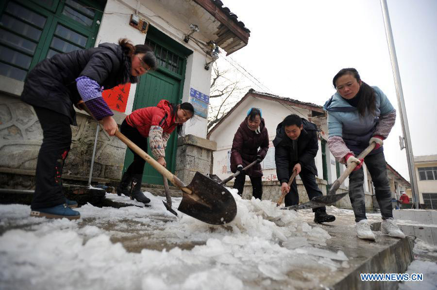 Teachers clean ice in a junior high school in Quanzhou County in Guilin, southwest China's Guangxi Zhuang Autonomous Region on Jan. 9, 2013. The meteorological observatory in Guangxi issued a yellow alert for frost on Wednesday afternoon. (Xinhua/Lu Bo'an)