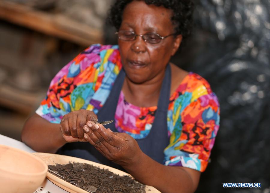 A woman processes clay materials at the Kazuri factory in Nairobi, Kenya, Jan. 8, 2013. Kazuri, which means "small and beautiful" in Swahili, began in 1975 as a workshop experimenting on making handmade beads. The factory employs over 340 women, mostly single mothers. Its handmade and hand-painted ceramic jewellery and pottery products have been exported to over 30 countries and regions worldwide. (Xinhua/Meng Chenguang)