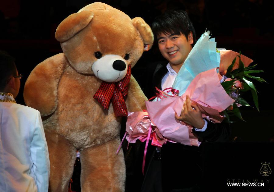 Pianist Lang Lang receives gifts presented by his fans during his new year concert in Wuhu City, east China's Anhui Province, Jan. 8, 2013. (Xinhua) 