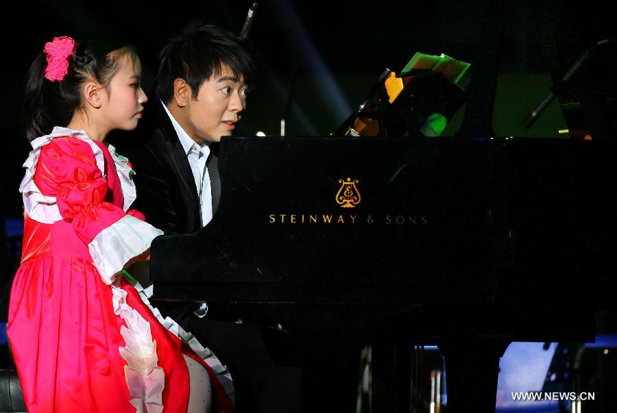Pianist Lang Lang and a young girl give performance during a new year concert in Wuhu City, east China's Anhui Province, Jan. 8, 2013. (Xinhua)