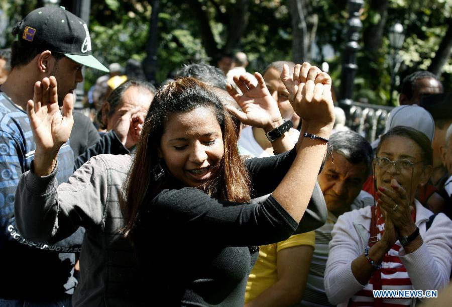 Supporters of Venezuelan President Hugo Chavez dance during a gathering near Venezuela's National Assembly in Caracas, capital of Venezuela, on Jan. 9, 2013. Venezuela's Supreme Court on Wednesday upheld the government's decision to delay the inauguration of ailing President Hugo Chavez, who is recovering from surgery in Havana, Cuba. (Xinhua/Juan Carlos Hernandez)