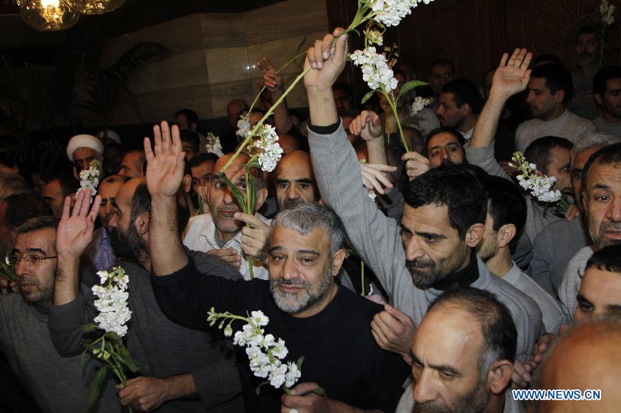 Released Iranian hostages cheer upon his arrival at the Sheraton Hotel in Damascus, Syria, Jan. 9, 2013. As many as 2,130 people were released from Syrian prisons in exchange of 48 kidnapped Iranians, a Turkish human rights activist told Xinhua Wednesday. In last August, a total of 48 Iranians were abducted by Syrian rebels in Damascus. Iran claimed them to be pilgrims, while the Syrian rebels alleged that they were Iranian military officials in Syria. (Xinhua/Bassem Tellawi)