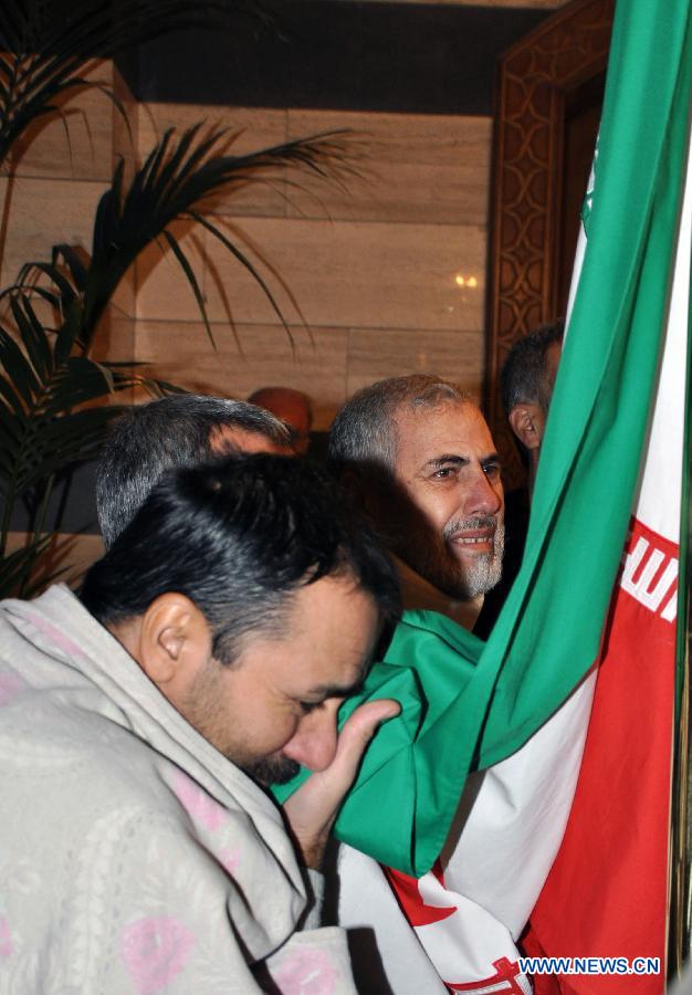 A released Iranian hostage kisses the Iranian national flag upon his arrival at the Sheraton Hotel in Damascus, Syria, Jan. 9, 2013. As many as 2,130 people were released from Syrian prisons in exchange of 48 kidnapped Iranians, a Turkish human rights activist told Xinhua Wednesday. In last August, a total of 48 Iranians were abducted by Syrian rebels in Damascus. Iran claimed them to be pilgrims, while the Syrian rebels alleged that they were Iranian military officials in Syria. (Xinhua/Bassem Tellawi)