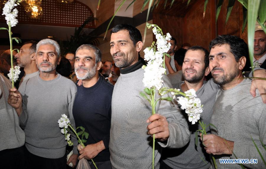 Released Iranian hostages pose for photo upon his arrival at the Sheraton Hotel in Damascus, Syria, Jan. 9, 2013. As many as 2,130 people were released from Syrian prisons in exchange of 48 kidnapped Iranians, a Turkish human rights activist told Xinhua Wednesday. In last August, a total of 48 Iranians were abducted by Syrian rebels in Damascus. Iran claimed them to be pilgrims, while the Syrian rebels alleged that they were Iranian military officials in Syria. (Xinhua/Bassem Tellawi)