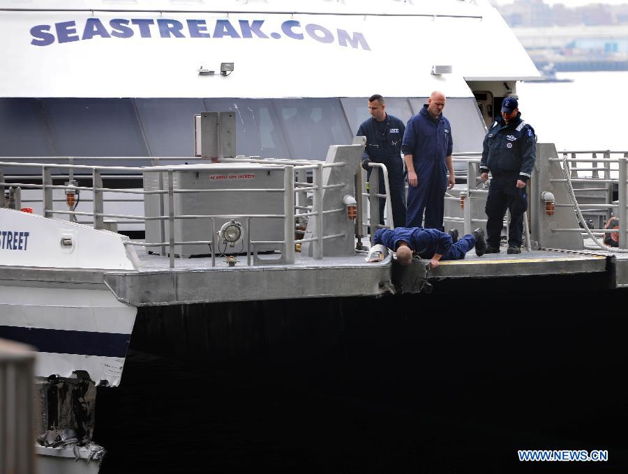Members of United States Coast Guard inspect a ferry boat which crashed into Pier 11 in lower Manhattan, New York, the United States, on Jan. 9, 2013. A high-speed ferry loaded with hundreds of commuters from New Jersey crashed into a dock near Wall Street on Wednesday during the morning rush hour, injuring 57 people. (Xinhua/Shen Hong)