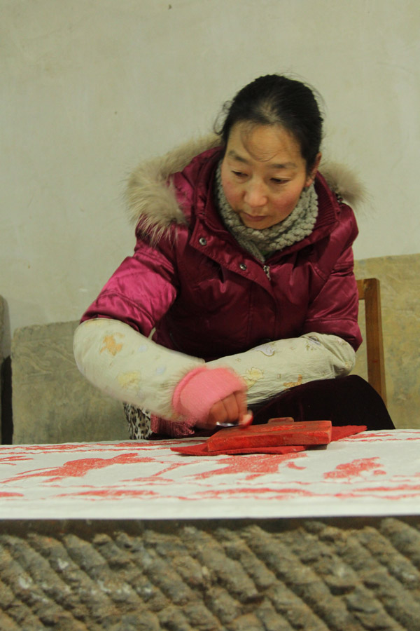 A member of staff at the Guanzhong Folk Art Museum in Xi'an, capital of China's northwestern Shaanxi province, works on a piece of gravestone rubbing, or "tapian" in Chinese. (CRIENGLISH.com/Liu Kun)  