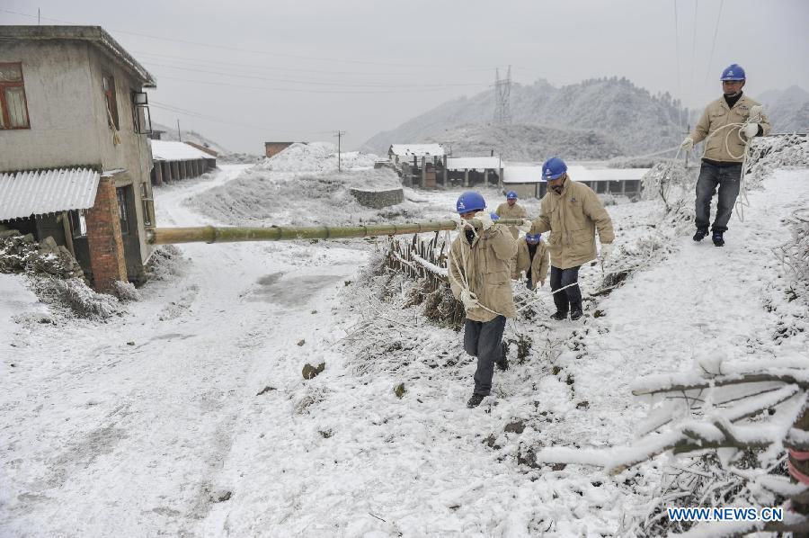 Workers carry a bamboo stick to clean the ice on the power line in Yongsha Village of Shuangliu Township in Kaiyang County, southwest China's Guiyang, Jan. 10, 2013. Local power grid company sent workers to clean power lines which couldn't melt the ice with automatic equipment. (Xinhua/Ou Dongqu) 
