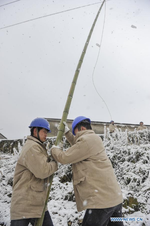 Workers clean ice on the power line with a bamboo stick in Yongsha Village of Shuangliu Township in Kaiyang County, southwest China's Guiyang, Jan. 10, 2013. Local power grid company sent workers to clean power lines which couldn't melt the ice with automatic equipment. (Xinhua/Ou Dongqu) 