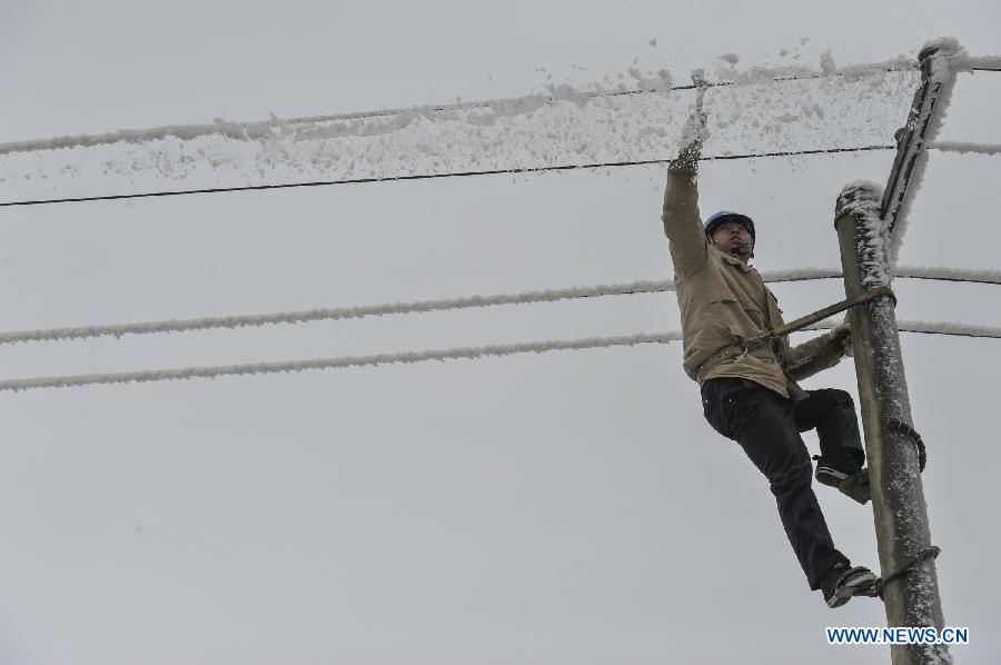 A worker cleans ice on the power line in Yongsha Village of Shuangliu Township in Kaiyang County, southwest China's Guiyang, Jan. 10, 2013. Local power grid company sent workers to clean power lines which couldn't melt the ice with automatic equipment. (Xinhua/Ou Dongqu) 