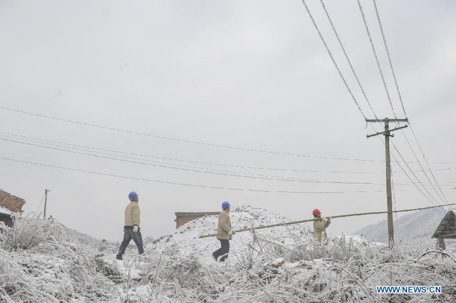 Workers clean ice on the power line with a bamboo stick in Yongsha Village of Shuangliu Township in Kaiyang County, southwest China's Guiyang, Jan. 10, 2013. Local power grid company sent workers to clean power lines which couldn't melt the ice with automatic equipment. (Xinhua/Ou Dongqu) 