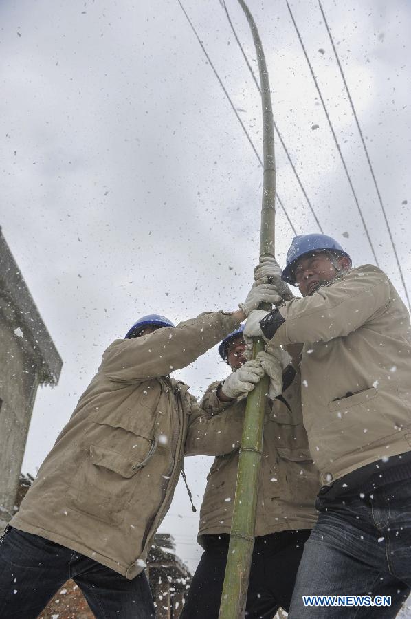 Workers clean ice on the power line with a bamboo stick in Yongsha Village of Shuangliu Township in Kaiyang County, southwest China's Guiyang, Jan. 10, 2013. Local power grid company sent workers to clean power lines which couldn't melt the ice with automatic equipment. (Xinhua/Ou Dongqu) 