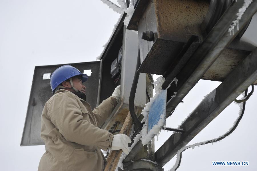 Workers check the power unit in Yongsha Village of Shuangliu Township in Kaiyang County, southwest China's Guiyang, Jan. 10, 2013. Local power grid company sent workers to clean power lines which couldn't melt the ice with automatic equipment. (Xinhua/Ou Dongqu) 