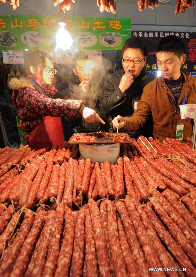 Visitors taste sausage at the 12th Western China (Chongqing) International Agricultural Products Fair in southwest China's Chongqing, Jan. 10, 2013. The fair kicked off here on Thursday. (Xinhua/Li Jian) 