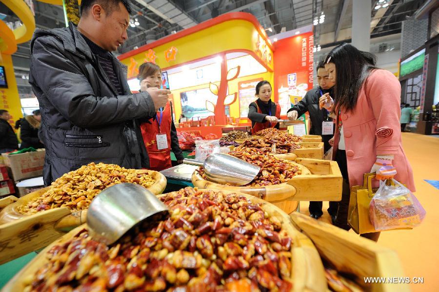 Visitors taste beans at the 12th Western China (Chongqing) International Agricultural Products Fair in southwest China's Chongqing, Jan. 10, 2013. The fair kicked off here on Thursday. (Xinhua/Li Jian) 
