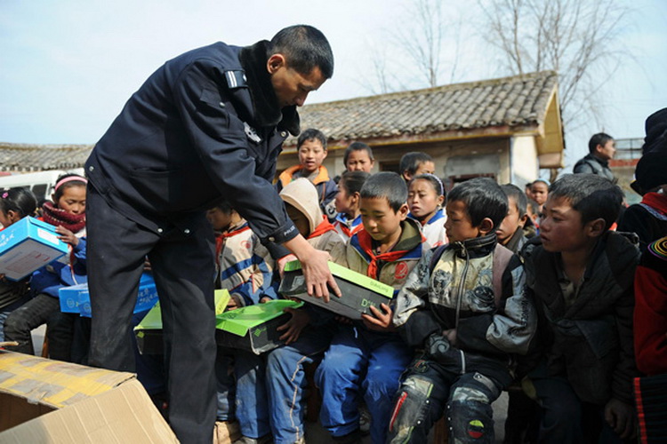 Zhu Dong donates shoes to students at Ersaixiang Primary School, Yuexi county, Southwest China's Sichuan province, on Jan 8, 2013. (Photo/Xinhua)