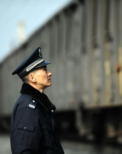 Zhu Dong sees off a train while patrolling a railway line in Yuexi county, Southwest China's Sichuan province, on Jan 8, 2013. (Photo/Xinhua)