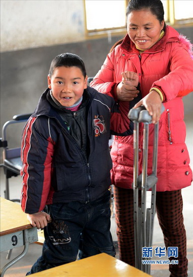 Wu Sulan takes care of his disabled son in the school on Jan. 9, 2013. (Xinhua/Song Zhenping)