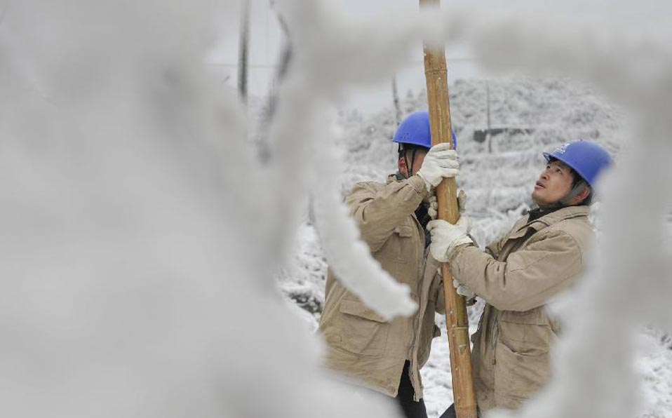 Workers clean ice on power lines in SW China