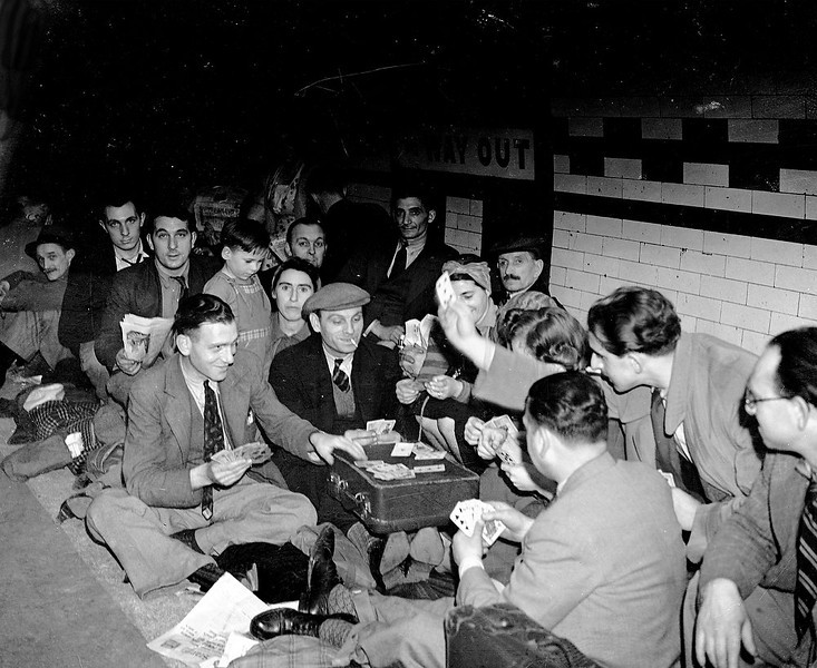 Londoners taking shelter in a London Underground station from the Nazi bombing raids, play cards through the night to pass the time, Sept. 25, 1940. (People's Daily Online/AP)
