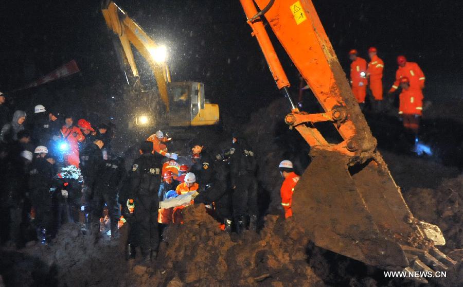 Rescuers and excavators work at the mud-inundated debris after a landslide hit Gaopo Village in Zhenxiong County, southwest China's Yunnan Province, Jan. 11, 2013. (Xinhua/Chen Haining)
