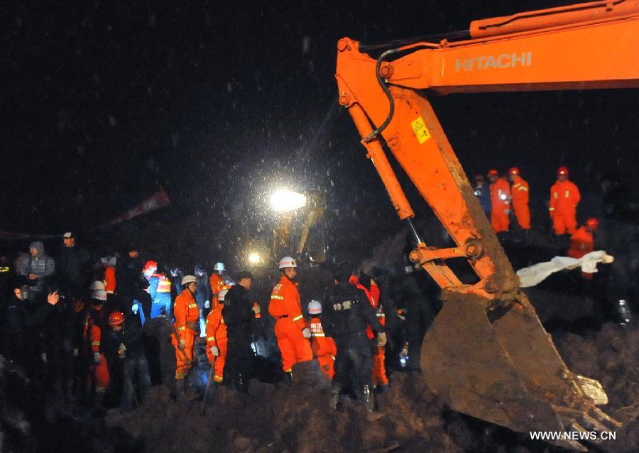 Rescuers and an excavator work at the mud-inundated debris after a landslide hit Gaopo Village in Zhenxiong County, southwest China's Yunnan Province, Jan. 11, 2013. (Xinhua/Chen Haining)