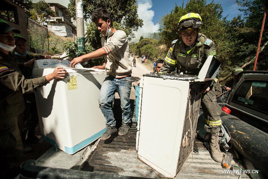 Firefighters evacuate residents due a forest fire in Cota, on the outskirts of Bogota, Colombia, on Jan. 11, 2013. According to local press, four acres have been consumed by the fire, and about 30 families were evacuated. (Xinhua/Jhon Paz)