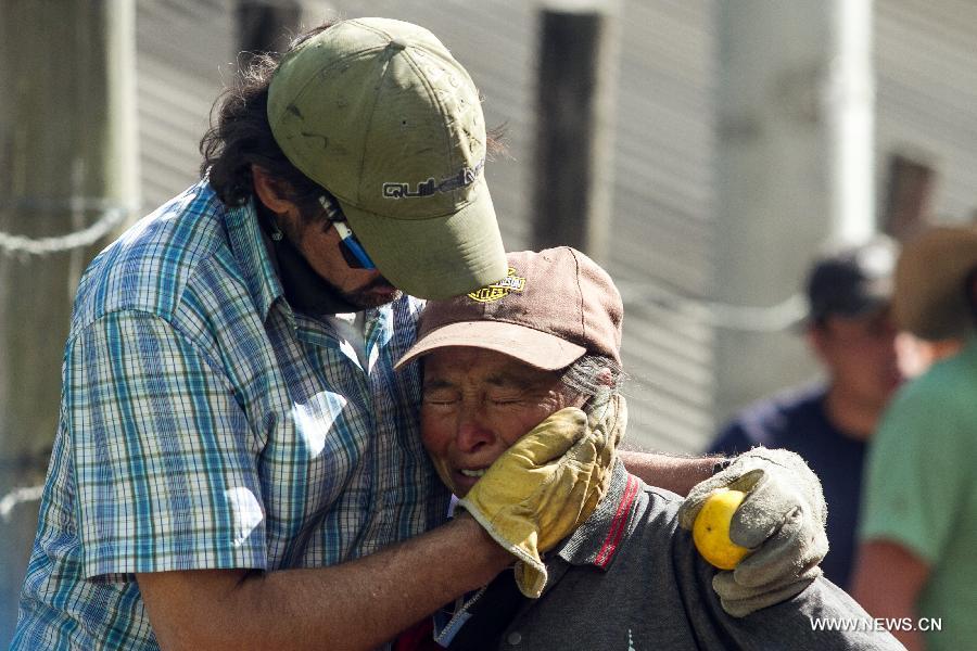 A woman reacts after being evacuated due to a forest fire in Cota, on the outskirts of Bogota, Colombia, on Jan. 11, 2013. According to local press, four acres have been consumed by the fire, and about 30 families were evacuated. (Xinhua/Jhon Paz)