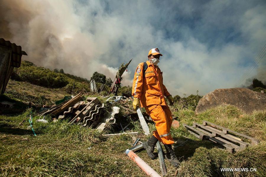 A member of Civil Defense tries to extinguish a forest fire in Cota, on the outskirts of Bogota, Colombia, on Jan. 11, 2013. According to local press, four acres have been consumed by the fire, and about 30 families were evacuated. (Xinhua/Jhon Paz)
