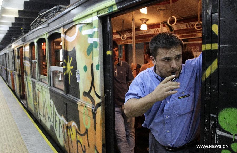 A guard announces departure of a convoy of the A line subway in Buenos Aires, Argentina, on Jan. 11, 2013. The A line subway service would be closed since Jan. 12 and the Belgian original historic wooden cars, which have been in service for almost 100 years, would be repalced by upgraded Chinese-made wagons. (Xinhua/Alberto Raggio)
