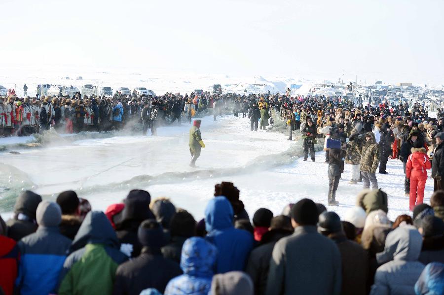 Tourists view winter fishing on the iced Ulunggur Lake in Fuhai County, northwest China's Xinjiang Uygur Autonomous Region, Jan. 12, 2013. The eighth Ulunggur Lake winter fishing festival kicked off in Fuhai on Saturday. (Xinhua/Sadat) 
