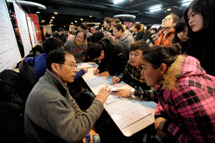 Job seekers inquire recruiters for information at a job fair in Shenyang, capital of northeast China's Liaoning Province, Jan. 12, 2013. A total of 168 companies provided some 3,000 job vacancies at the job fair. (Xinhua) 