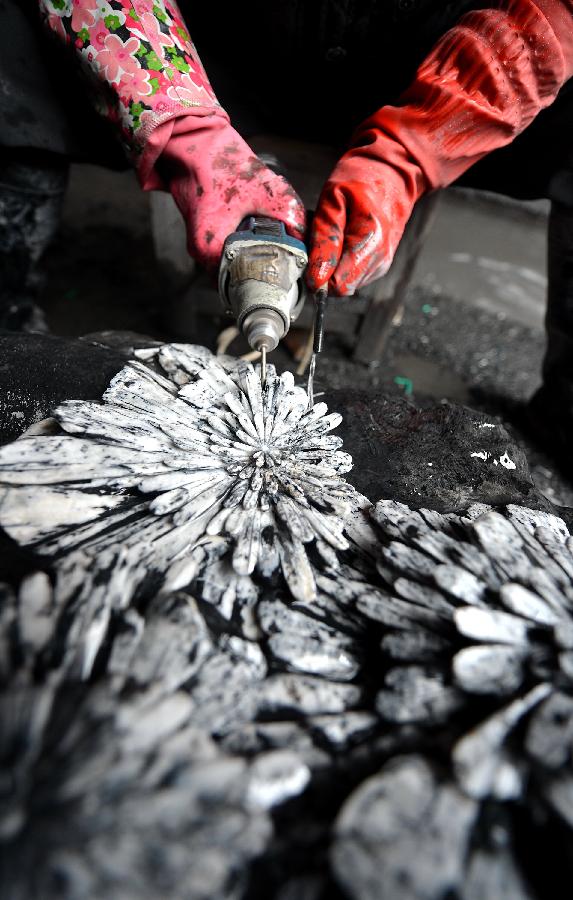 A craftsman named Yang Yunkai carves a semi-finished handicraft made of chrysanthemum stone in a workshop in Enshi, central China's Hubei Province, Jan. 12, 2013.(Xinhua/Song Wen) 