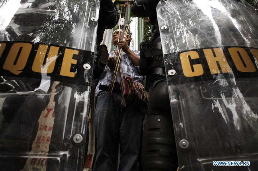 An Indian man (C) looks at Special Police Operations Battalion (BOPE) members during a BOPE operation to evict a group of Indians camping in the Indian Museum, in Rio de Janeiro, Brazil, on Jan. 12, 2013. On Saturday morning, BOPE's members arrived at the museum that will be demolished to evict the Indians. The demolition was carried out with the aim of building modernization works to the adjoining Maracana Stadium, as part of the preparations for Brazil's World Cup 2014. (Xinhua/Luiz Roberto Lima/AGENCIA ESTADO)