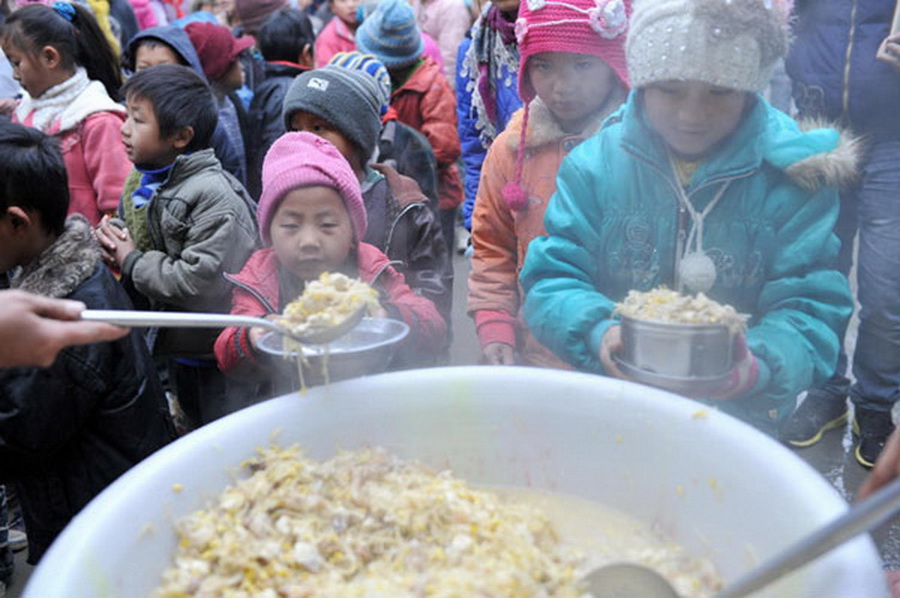 13.	Students get free lunch at Longdong Primary School in Longlin county, Guangxi Zhuang autonomous region, Jan 8, 2013. Free lunch covers 1.16 million rural students in 40 counties and regions in Guangxi. Since autumn 2011, with the release of "Guidance on Nutritional Improvement Plan for Rural Students" by the State Council, the free lunch program sponsored by city and county governments has become nationally funded. (Photo/Xinhua)