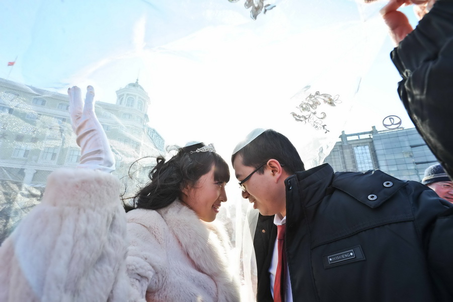 A couple from Jiangsu is at the wedding ceremony on Jan. 6, 2013. 16 newlyweds from China and abroad attended the 29th international ice-snow collective wedding ceremony in Harbin.  (Xinhua/ Wang Song)