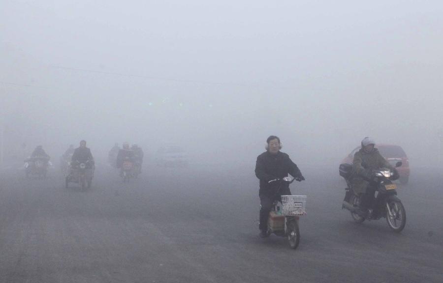 Citizens ride in the fog on a street in Ganyu County of Lianyungang City, east China's Jiangsu Province, Jan. 13, 2013. Dense fog on Sunday hit China's east and central regions from the northeast to the south. (Xinhua/Si Wei)