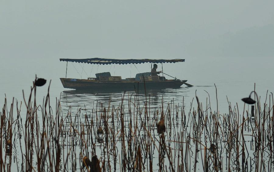 Photo taken on Jan. 13, 2013 shows a boat on the West Lake in the fog in Hangzhou, capital of east China's Zhejiang Province. Dense fog on Sunday hit China's east and central regions from the northeast to the south, causing serious air pollution. (Xinhua) 