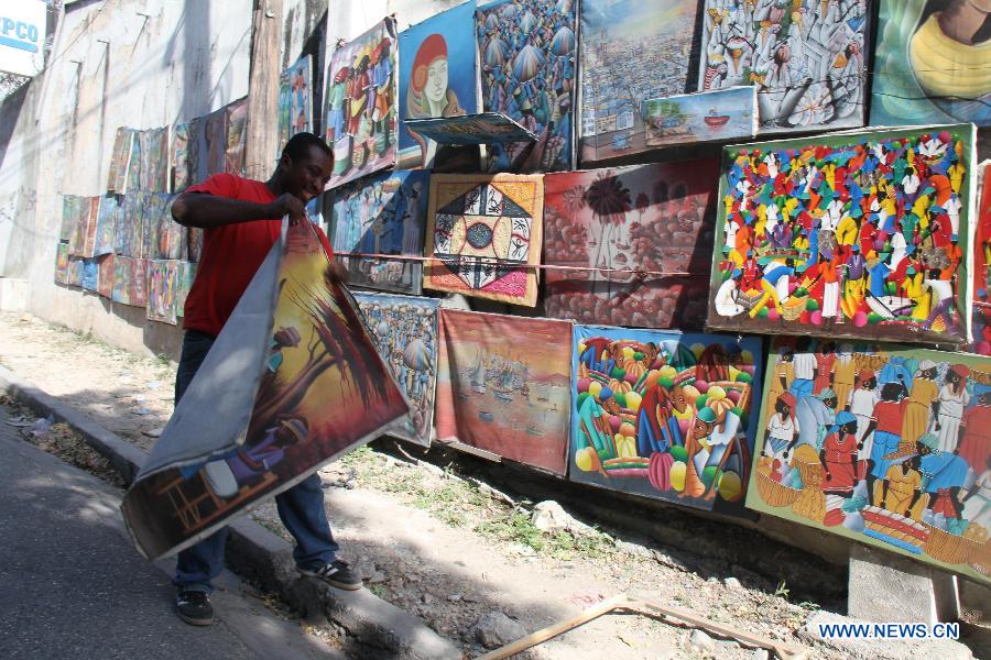 A man place a poster into a wall in the city of Port au Prince, capital of Haiti, on Jan. 12, 2013. Haitian President Michel Martelly called for patience from survivors on Saturday on the third anniversary of the 2010 earthquake that killed more than 200,000 people. (Xinhua/Zhu Qingxiang) 