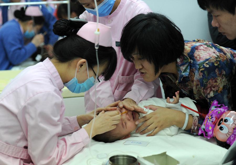 A nurse gives a child transfusion at Beijing Children's Hospital in Beijing, capital of China, Jan. 13, 2013. Beijing was shrouded in dense smog for a 3rd straight day on Sunday. Winter has always been a high-occurrence season for respiratory infection diseases. The recent smog in Beijing caused an increase in children's respiratory infection. (Xinhua/Luo Xiaoguang) 