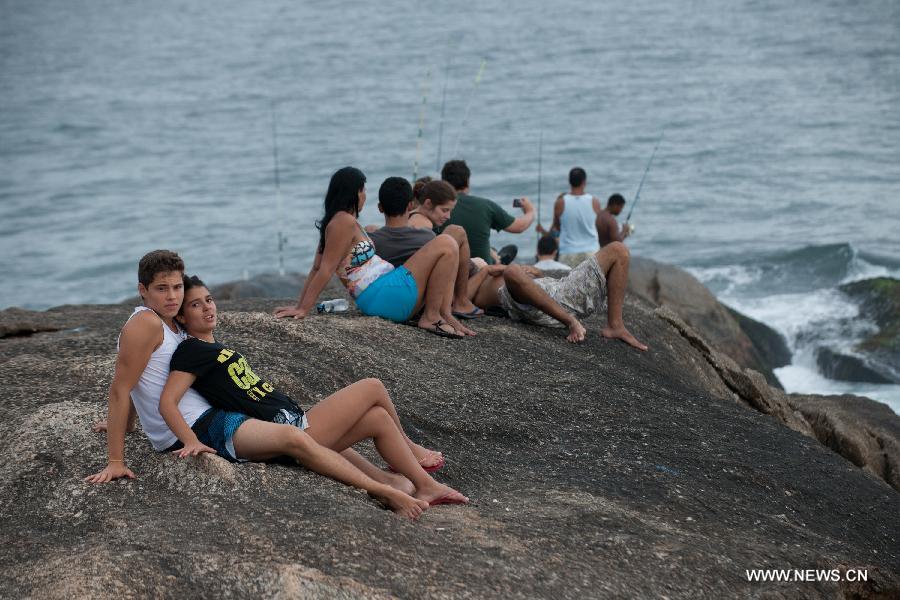 A pair of youngsters are seen on a rock in Arpoador in Rio de Janeiro, Brazil, Jan. 13, 2013.(Xinhua/Weng Xinyang)