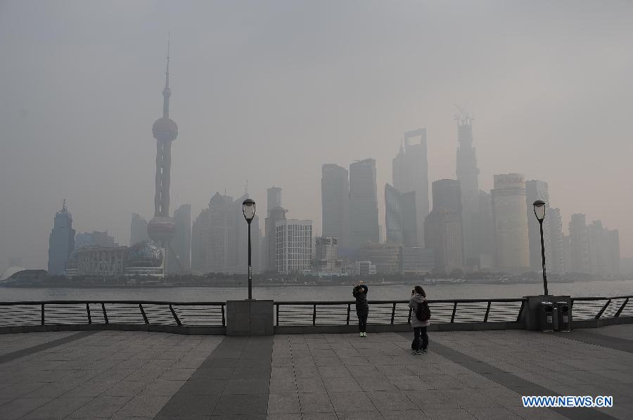 Tourists take photos amid heavy fog in Shanghai, east China, Jan. 14, 2013. Emergency response measures were adopted in many Chinese cities, where the air has held excessive levels of major pollutants in the past few days due to prolonged fog and smog. Heavy fog has caused highway closures and flight delays in several provinces. The elderly, children and those suffering from respiratory and cardiovascular diseases are advised to stay indoors to reduce exposure to polluted air. (Xinhua/Liu Xiaojing)