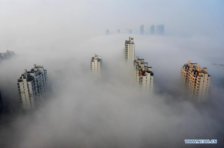 Skyscrapers are partly seen amid thick fog in Suzhou, capital of east China's Jiangsu Province, Jan. 14, 2013. Emergency response measures were adopted in many Chinese cities, where the air has held excessive levels of major pollutants in the past few days due to prolonged fog and smog. Heavy fog has caused highway closures and flight delays in several provinces. The elderly, children and those suffering from respiratory and cardiovascular diseases are advised to stay indoors to reduce exposure to polluted air. (Xinhua/Yao Jianping)