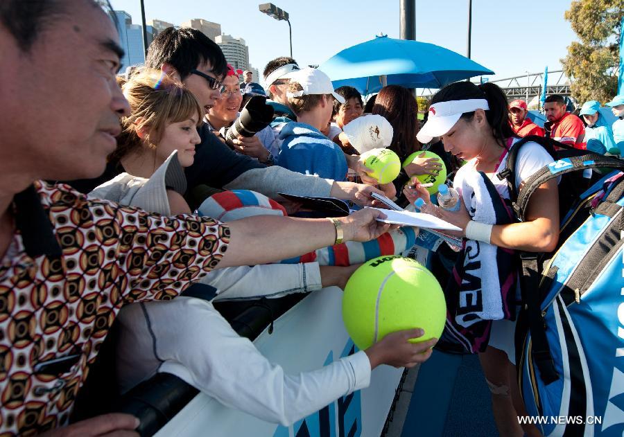 Zheng Jie (R) of China autographs for the fans after winning her first round women's singles match against Zhang Yuxuan of China on the first day of 2013 Australian Open tennis tournament in Melbourne, Australia, Jan. 14, 2013. (Xinhua/Bai Xue) 
