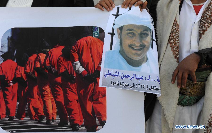 Family members of a Yemeni prisoner in Guantanamo display a picture of him during a rally demanding the release of prisoners held in Guantanamo, in front of the Yemeni President's Palace, in Sanaa, Yemen, Jan. 14, 2013. (Xinhua/Mohammed Mohammed)